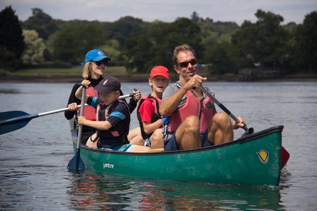 A family enjoying a paddle to the pub.