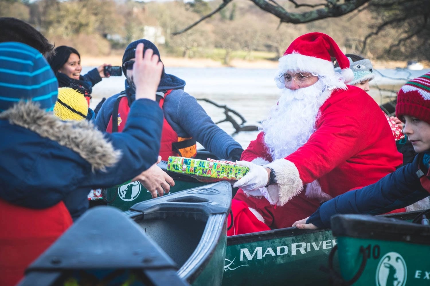 A group of children receiving gifts from Santa on the Beaulieu River.