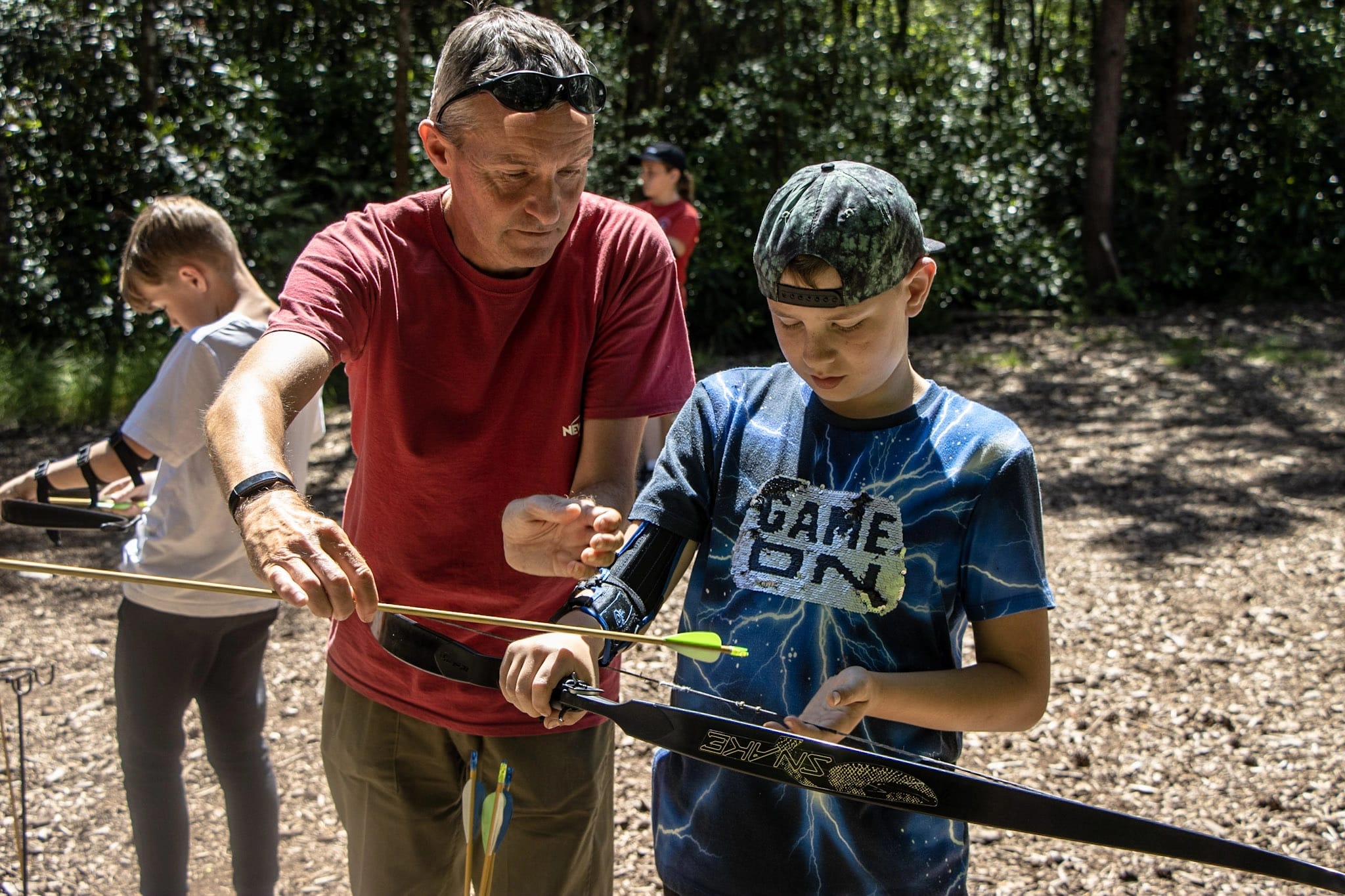 An instructor delivering an archery session to a group of children