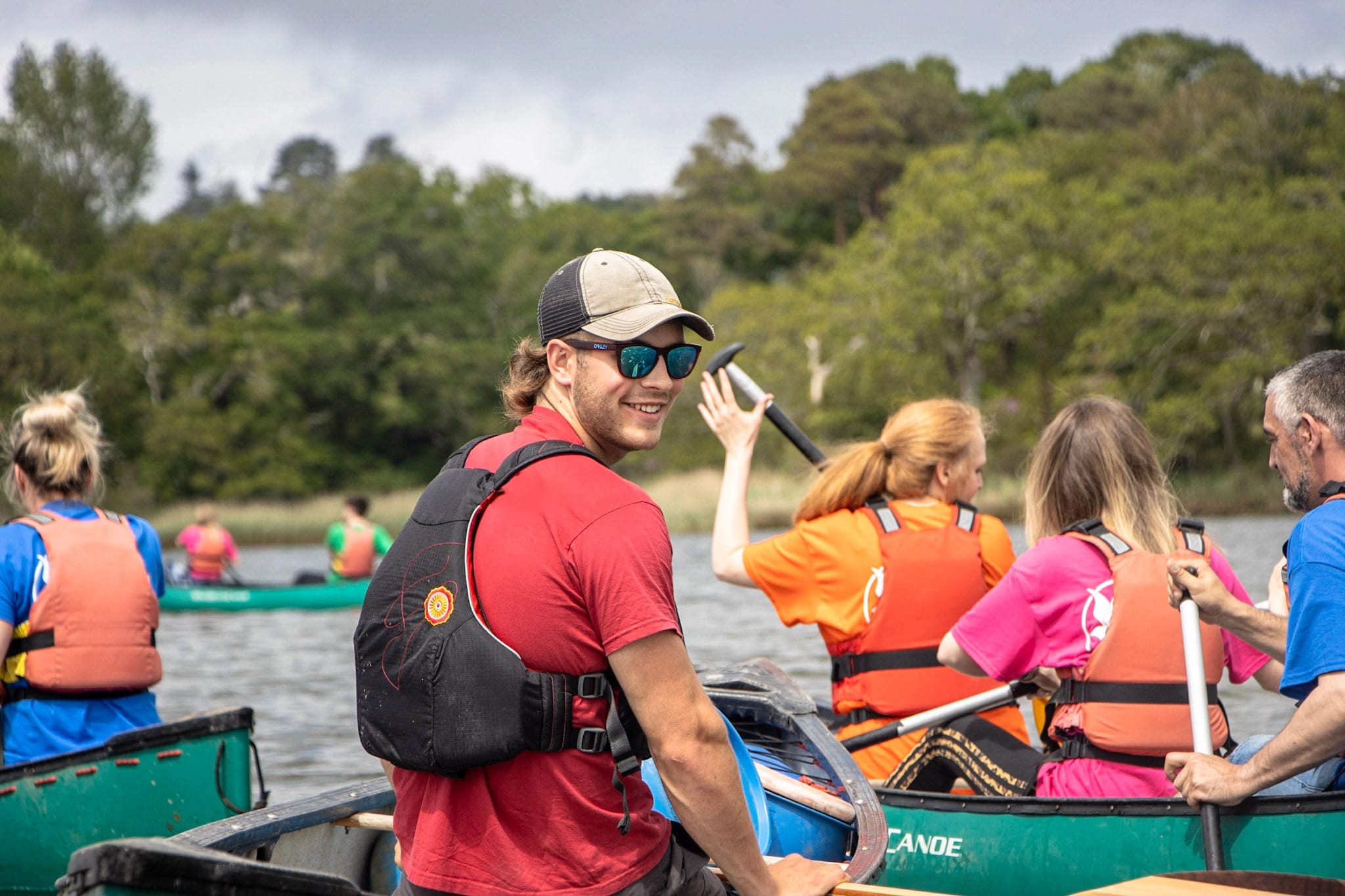 An Outdoor instructor smiling whilst delivering a canoeing session